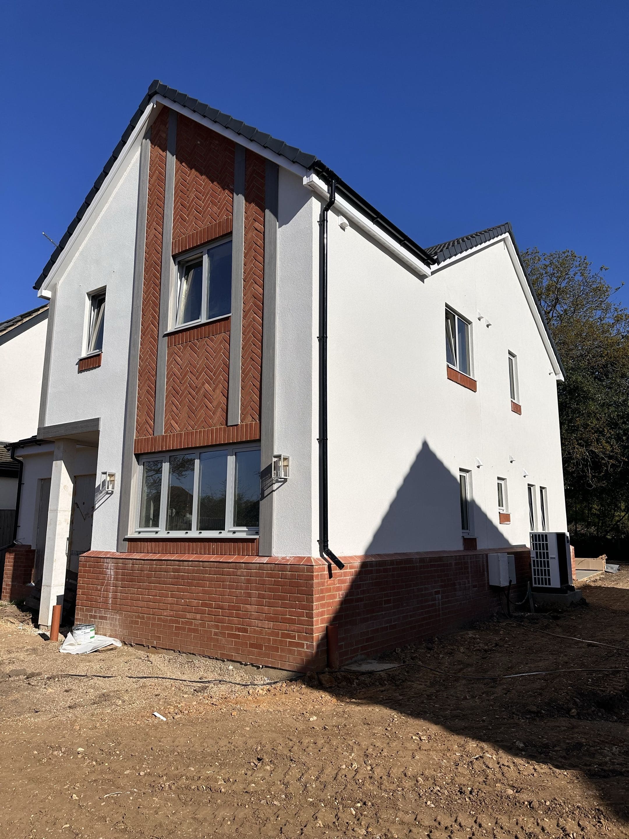 New build render finish with herringbone brick detailing, Bedmond